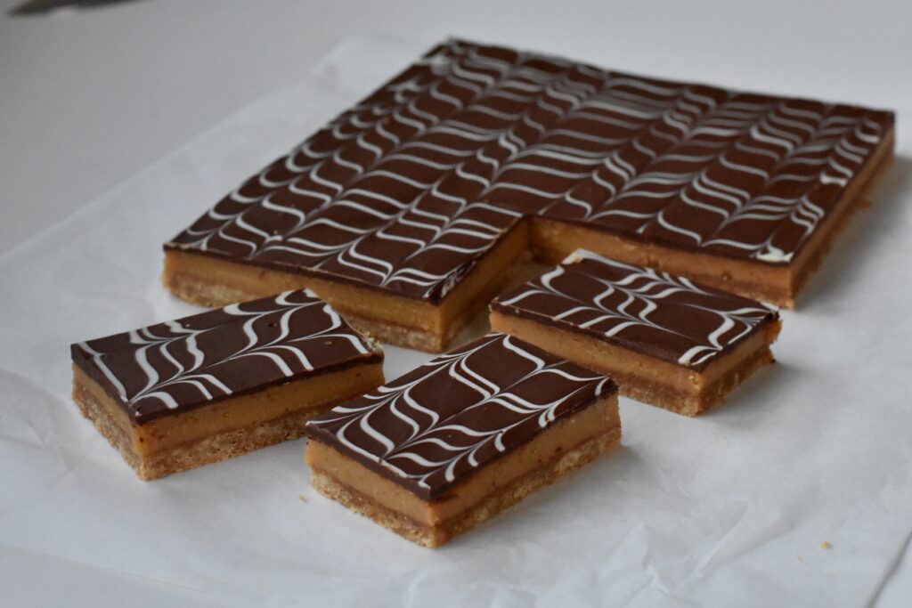 Caramel Slice pieces on baking paper.