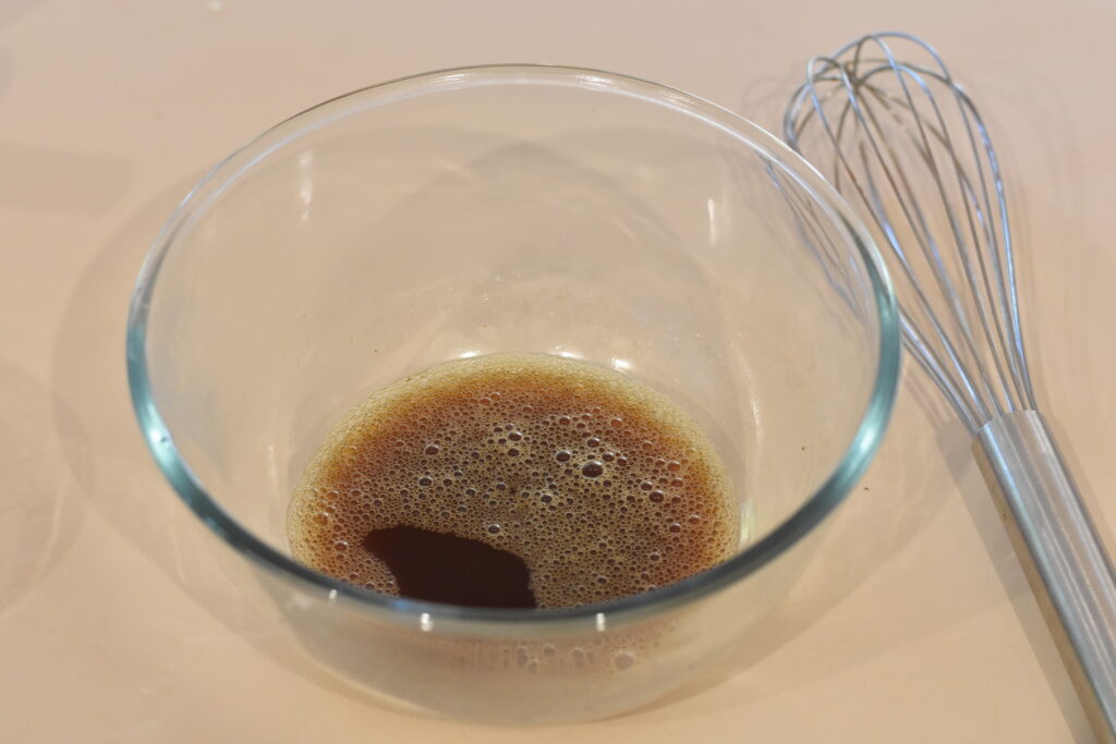 Coffee granules dissolved in water in a bowl.