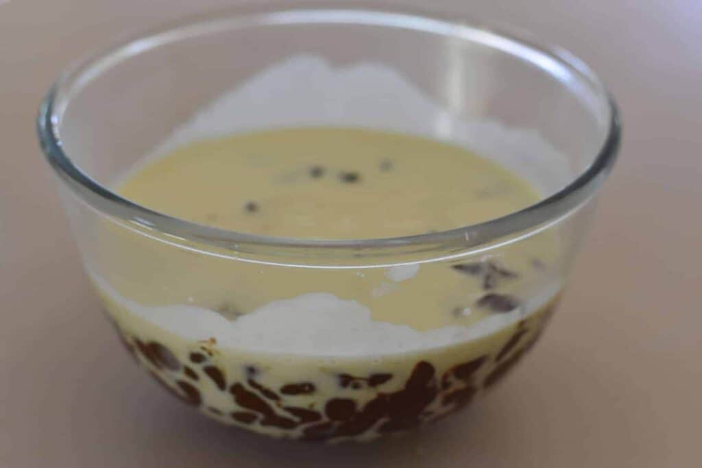 Hot cream on top of chocolate chips in a bowl.