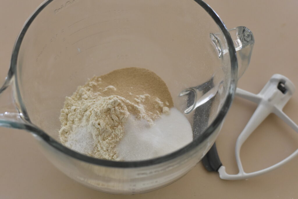 Flour, yeast, sugar and salt combined in mixer bowl.