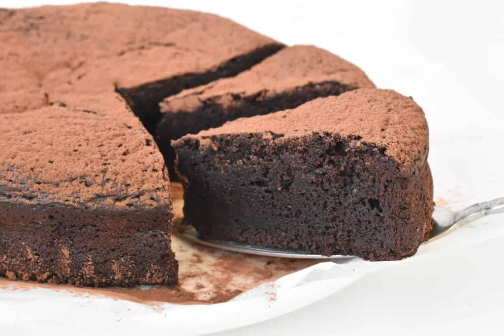 Slice of flourless chocolate cake on cake server.