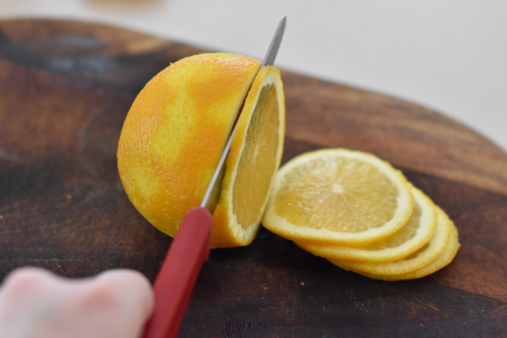 Oranges being thinly sliced.