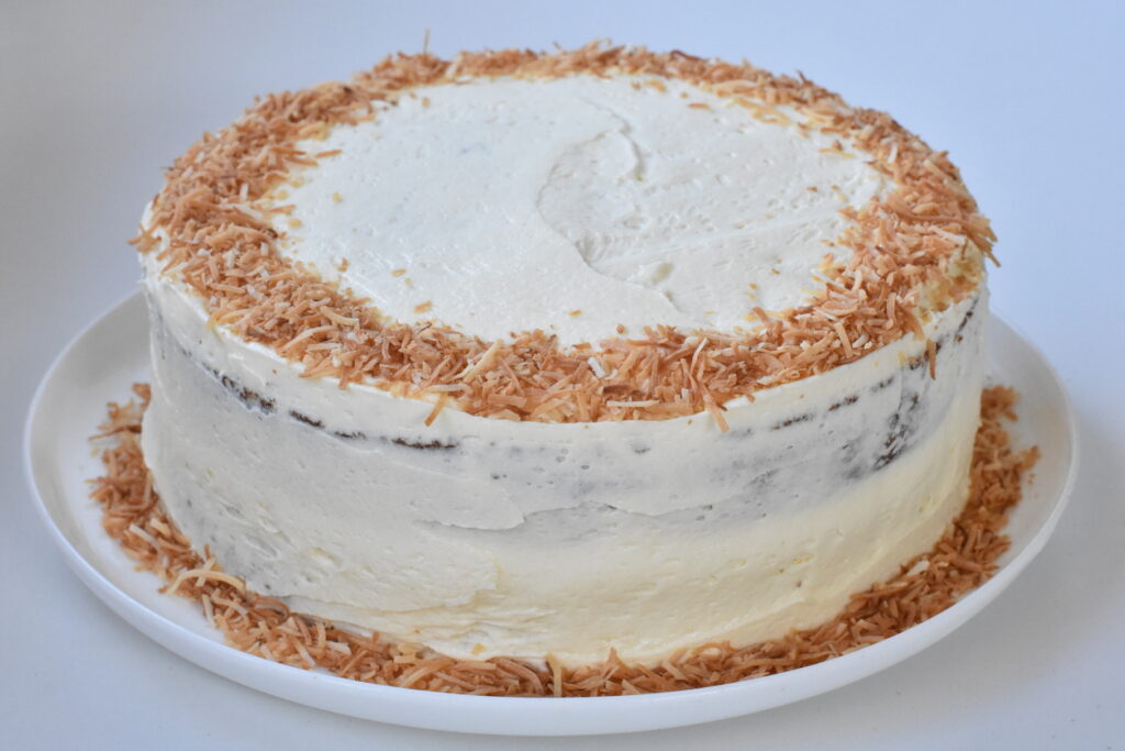 .Finished hummingbird cake topped with ring of toasted coconut.