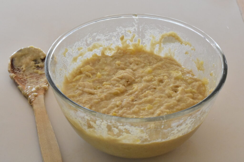 Batter in a mixing bowl with a wooden spoon.