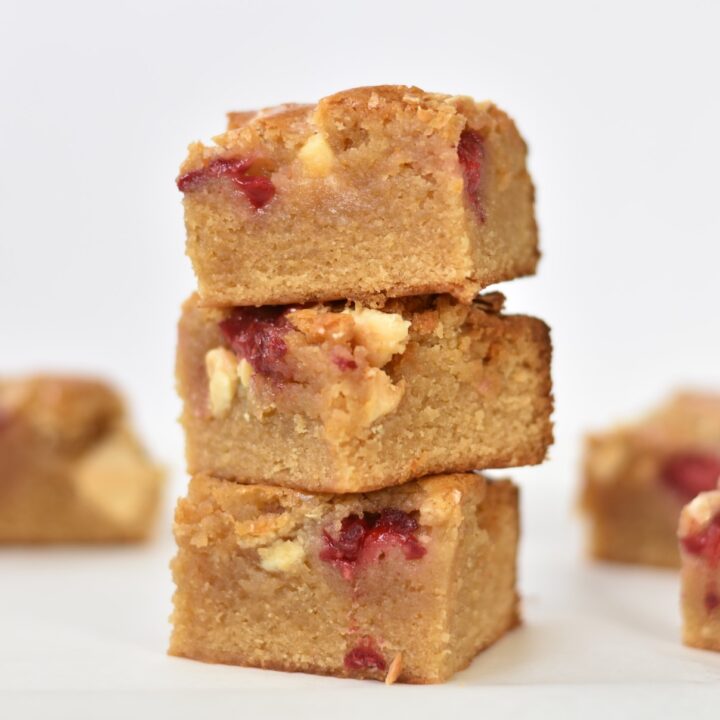 White Chocolate and Raspberry Blondies stacked in a pile.