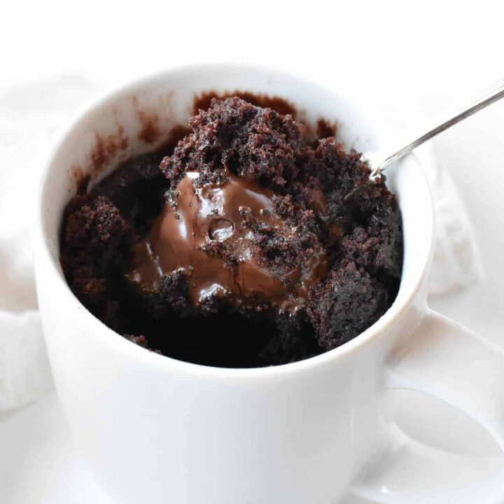 Chocolate lava mug cake after cooking with spoon.
