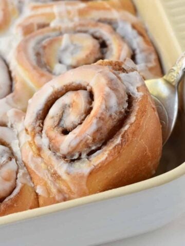 Cinnamon Roll being lifted out of tray