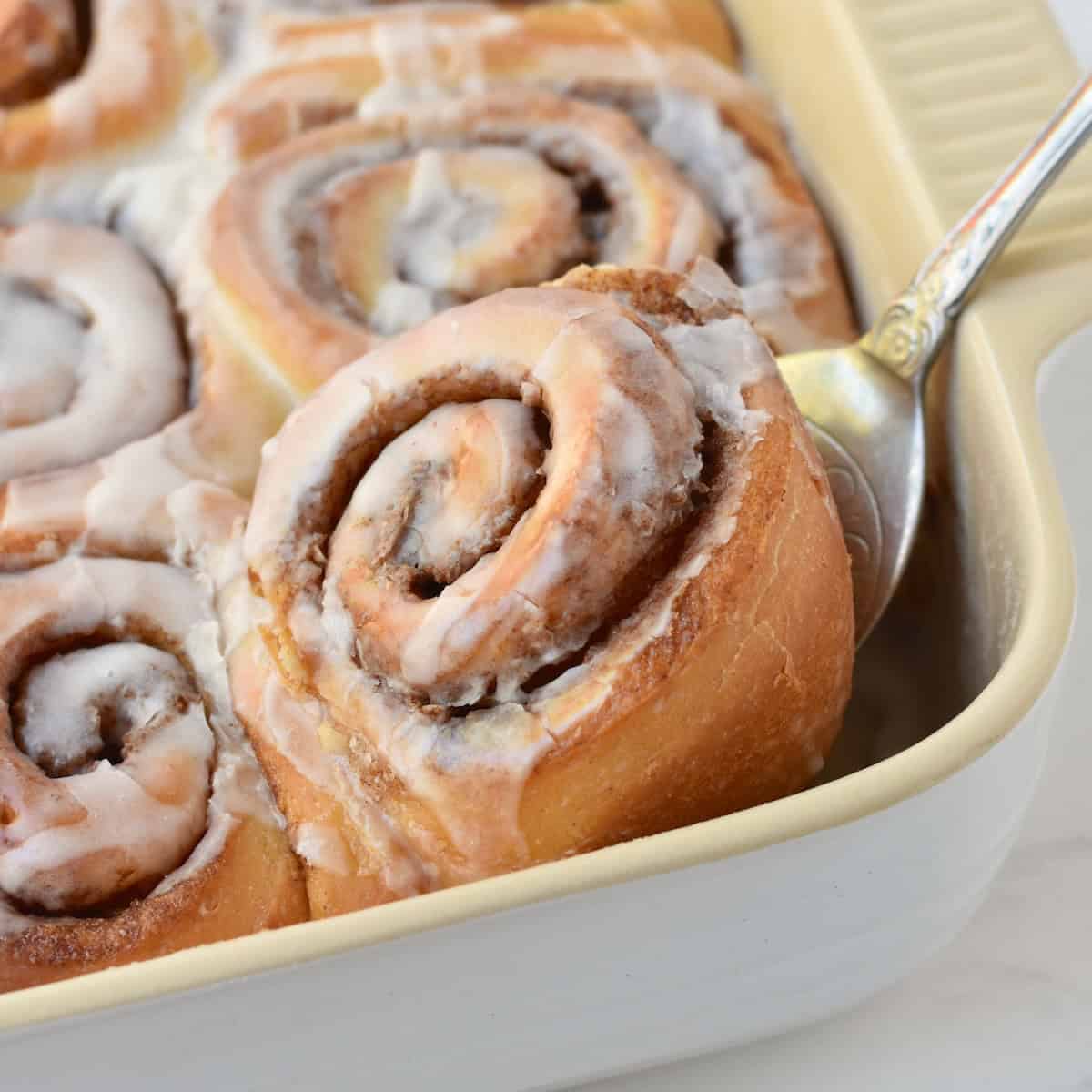 Cinnamon Roll being lifted out of tray