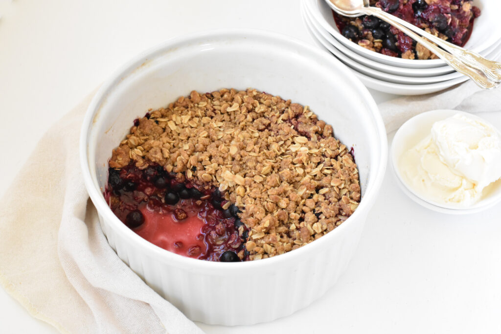 Mixed Berry Crumble being served with ice cream.