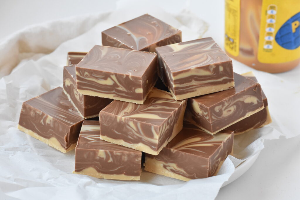 Squares of peanut butter swirl fudge on plate.