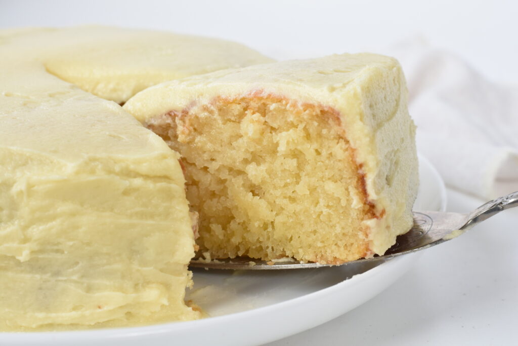Slice of Vanilla Cake with Buttercream on cake server.