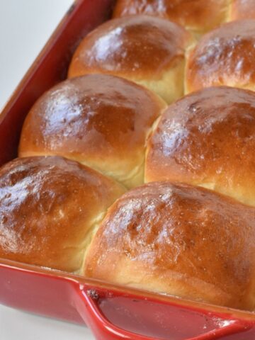Dinner rolls baked in red tray.