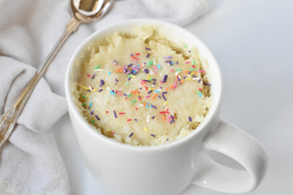 Vanilla mug cake topped with sprinkles.