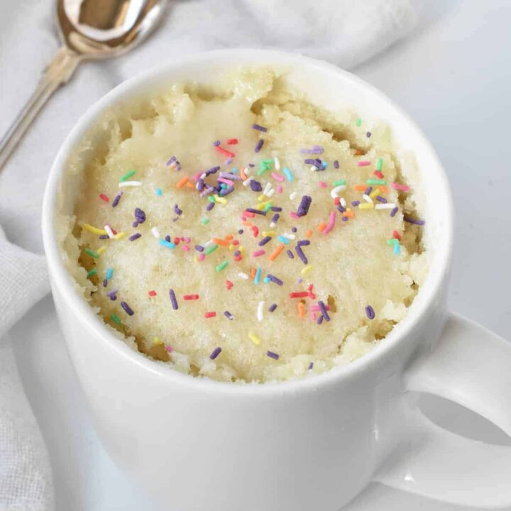 Vanilla mug cake topped with sprinkles.