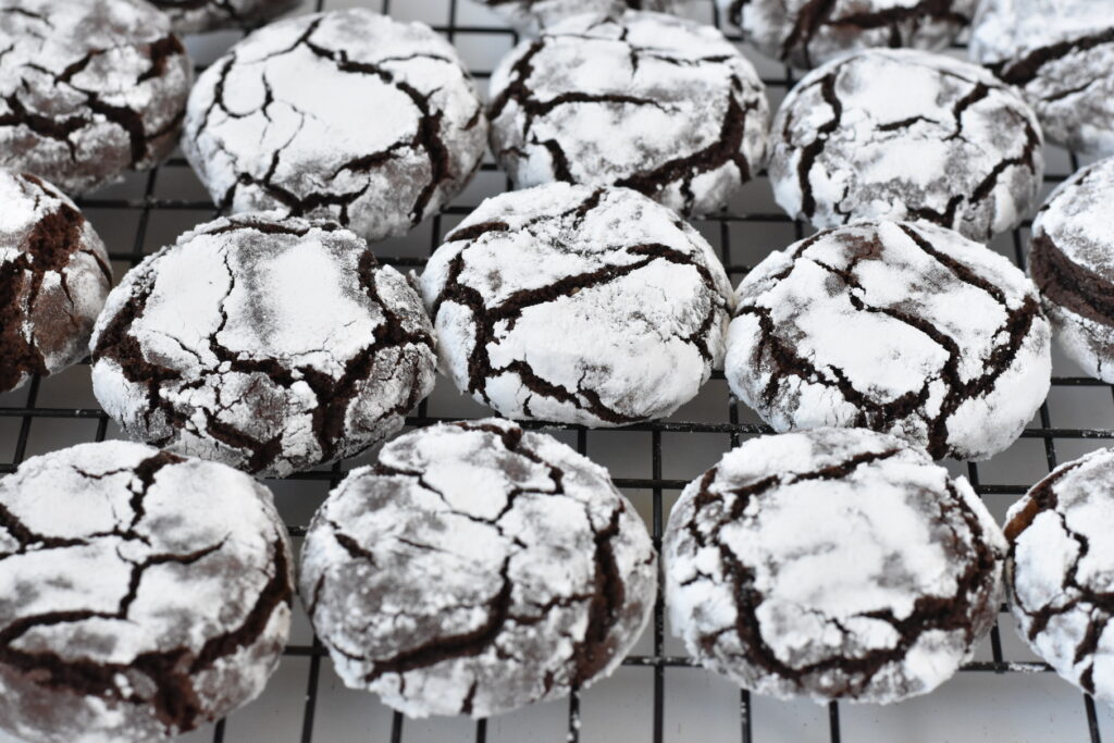 Chocolate crinkle cookies on cooling rack.