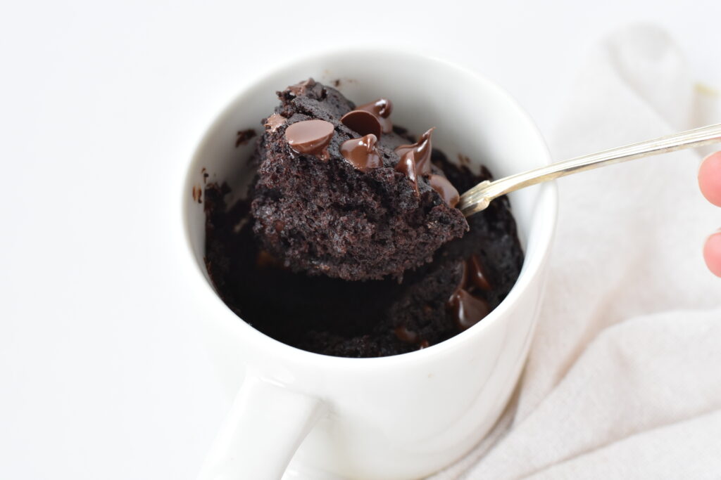 Big scoop of double chocolate chip muffin in a mug.