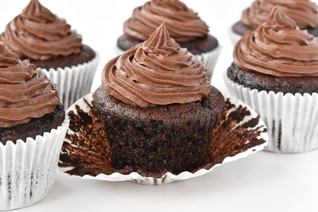 Unwrapped chocolate cupcake decorated with swirl of buttercream.