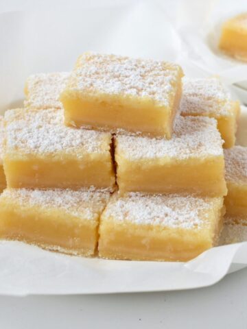 Lemon Coconut Bars stacked on a plate.