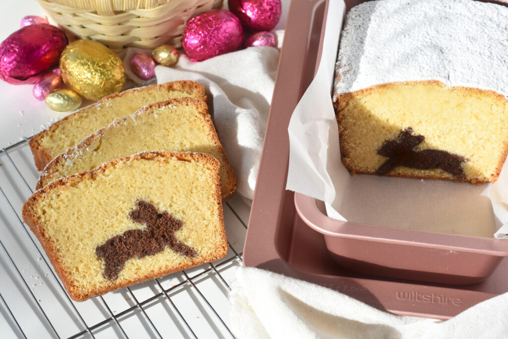 Three slices of bunny cake on baking tray next to loaf tin.