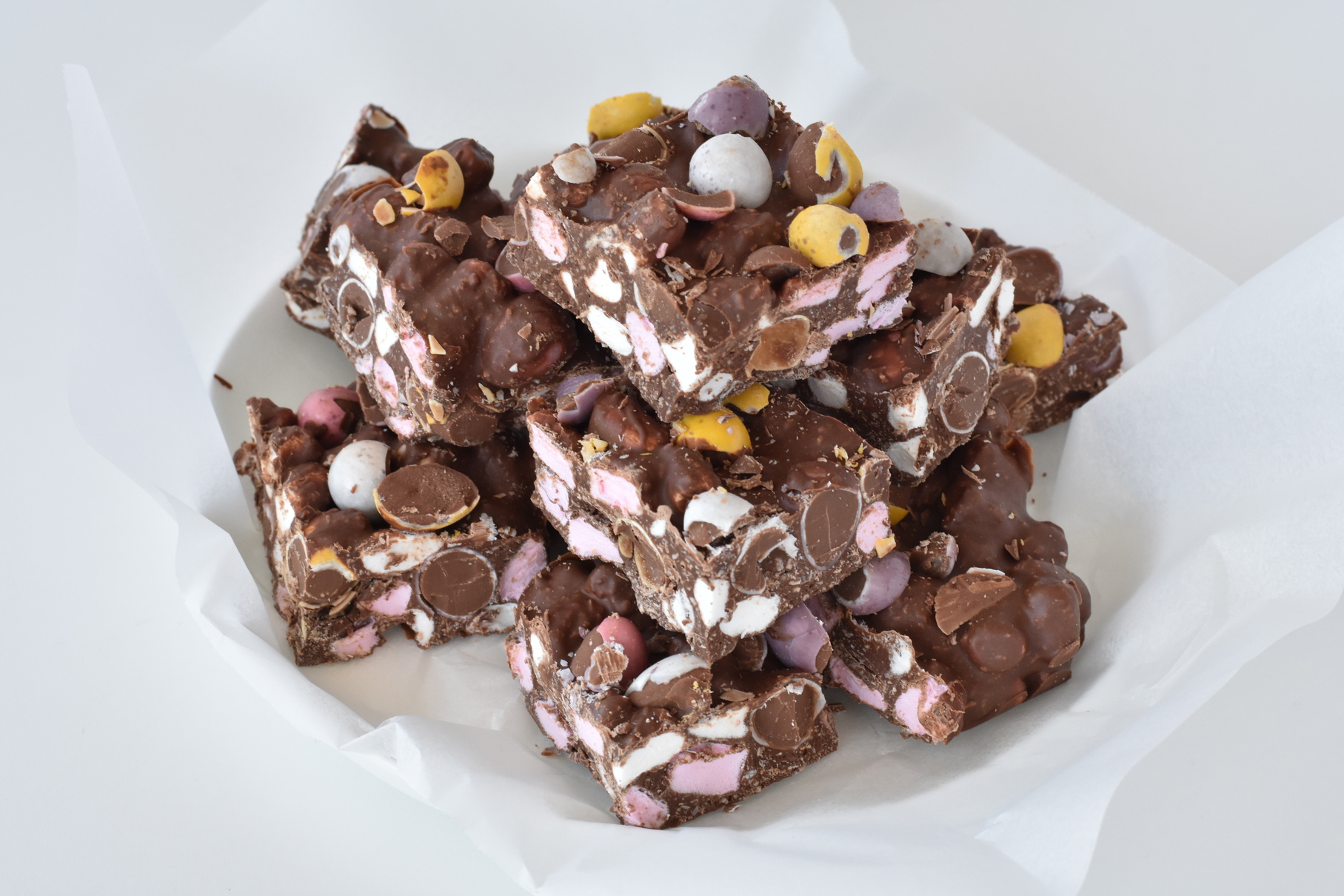 Squares of rocky road stacked on a plate.