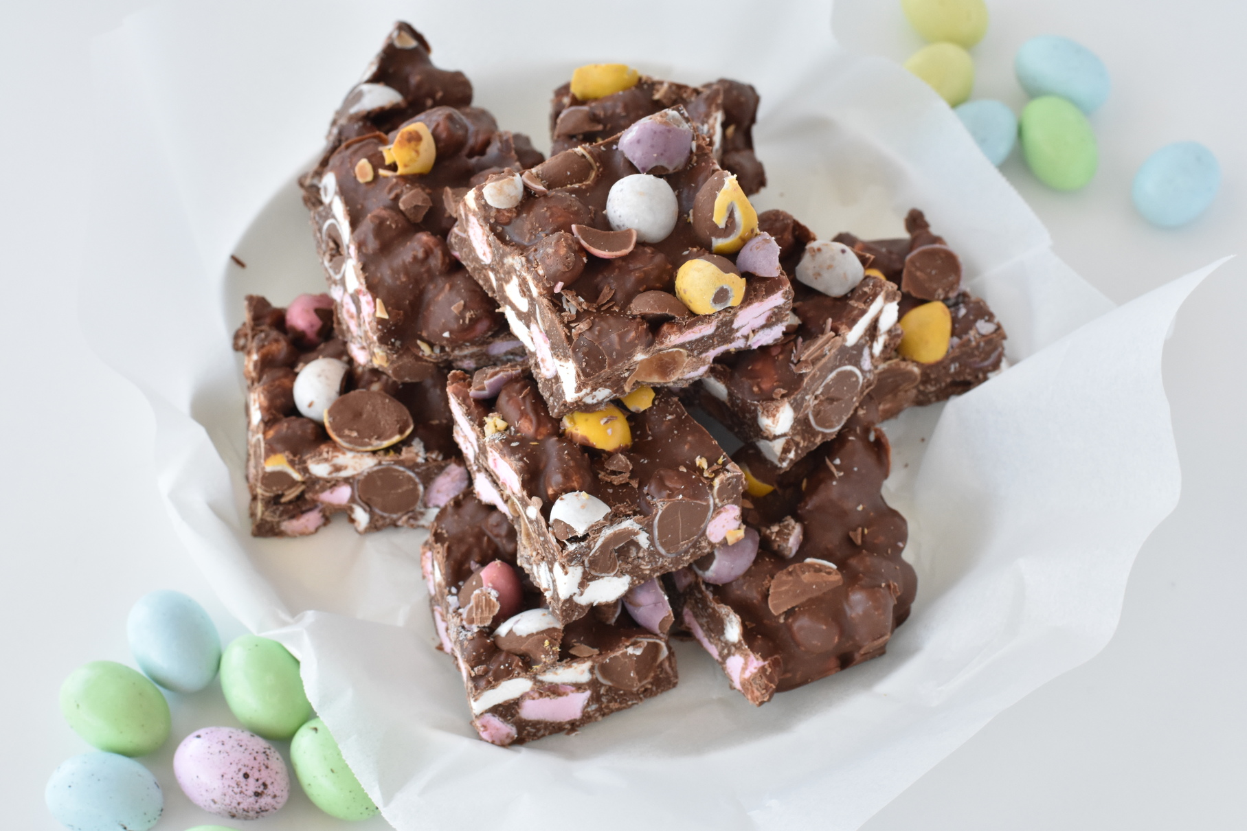 Squares of rocky road stacked on a plate.