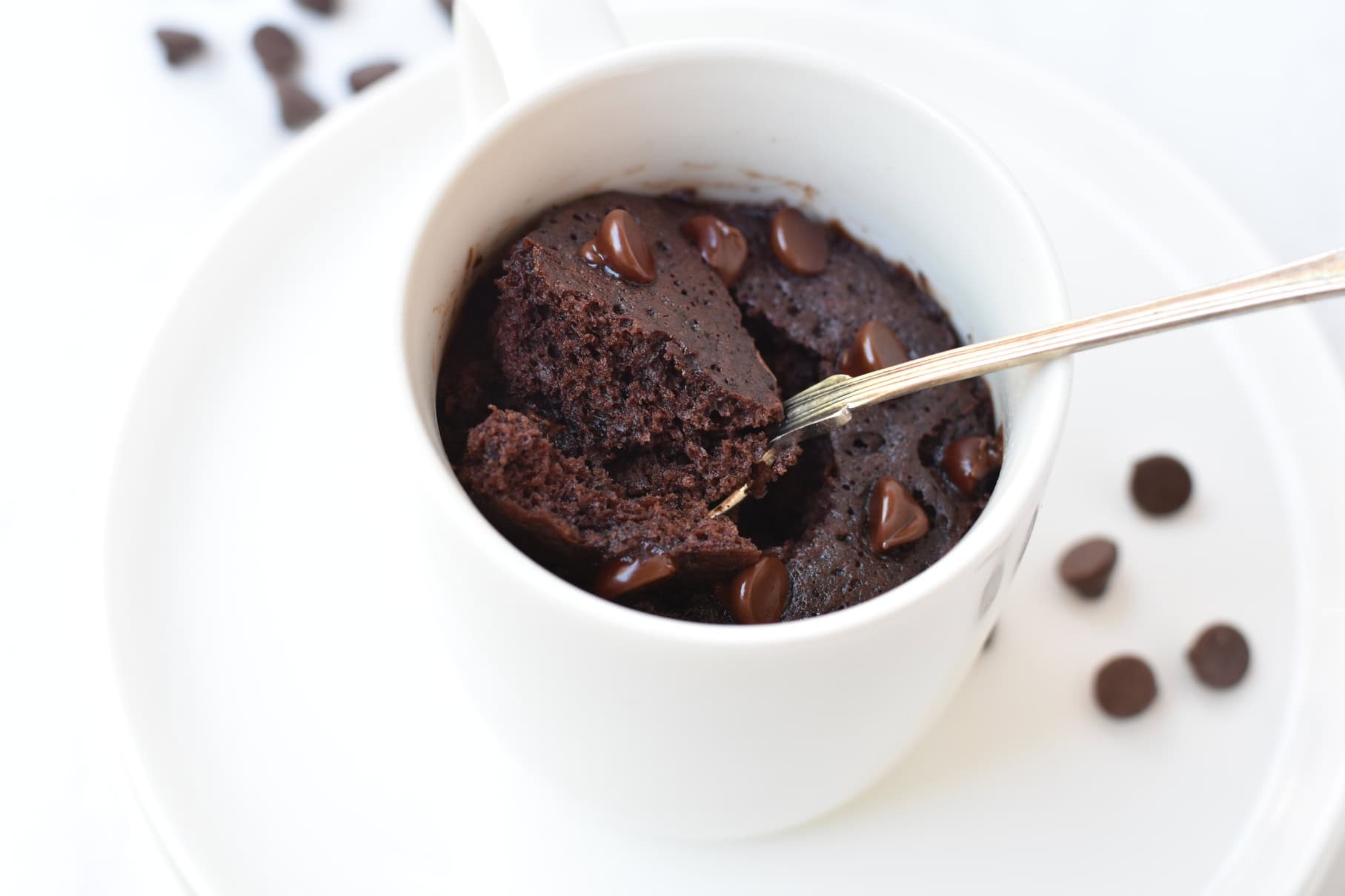 Mug cake being scooped out of mug with spoon.