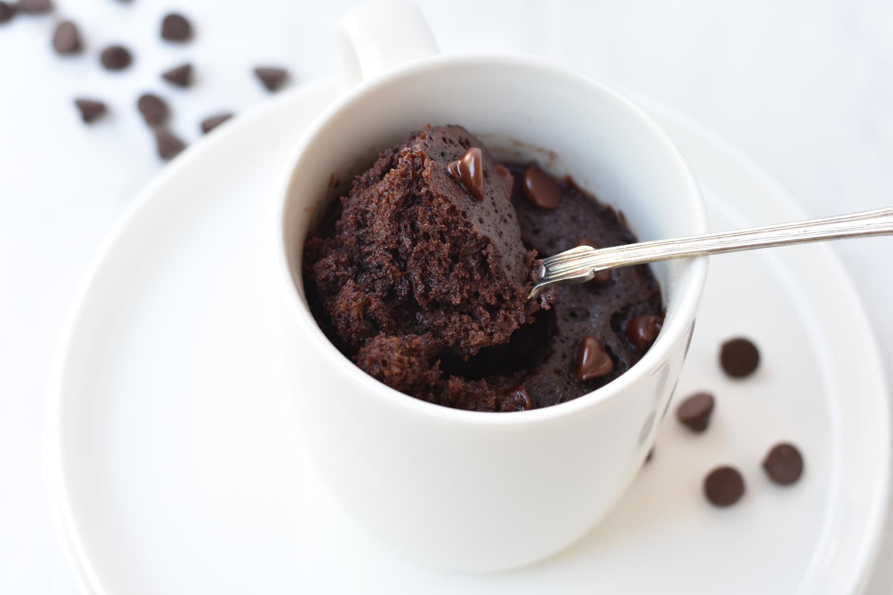 Mug cake being scooped out of mug with spoon.