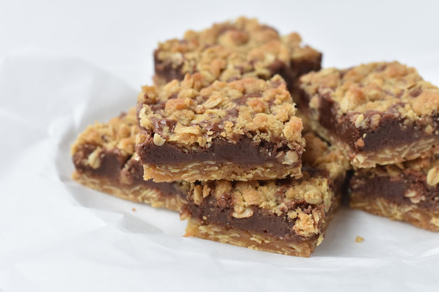 Sliced oat fudge bars stacked on plate.