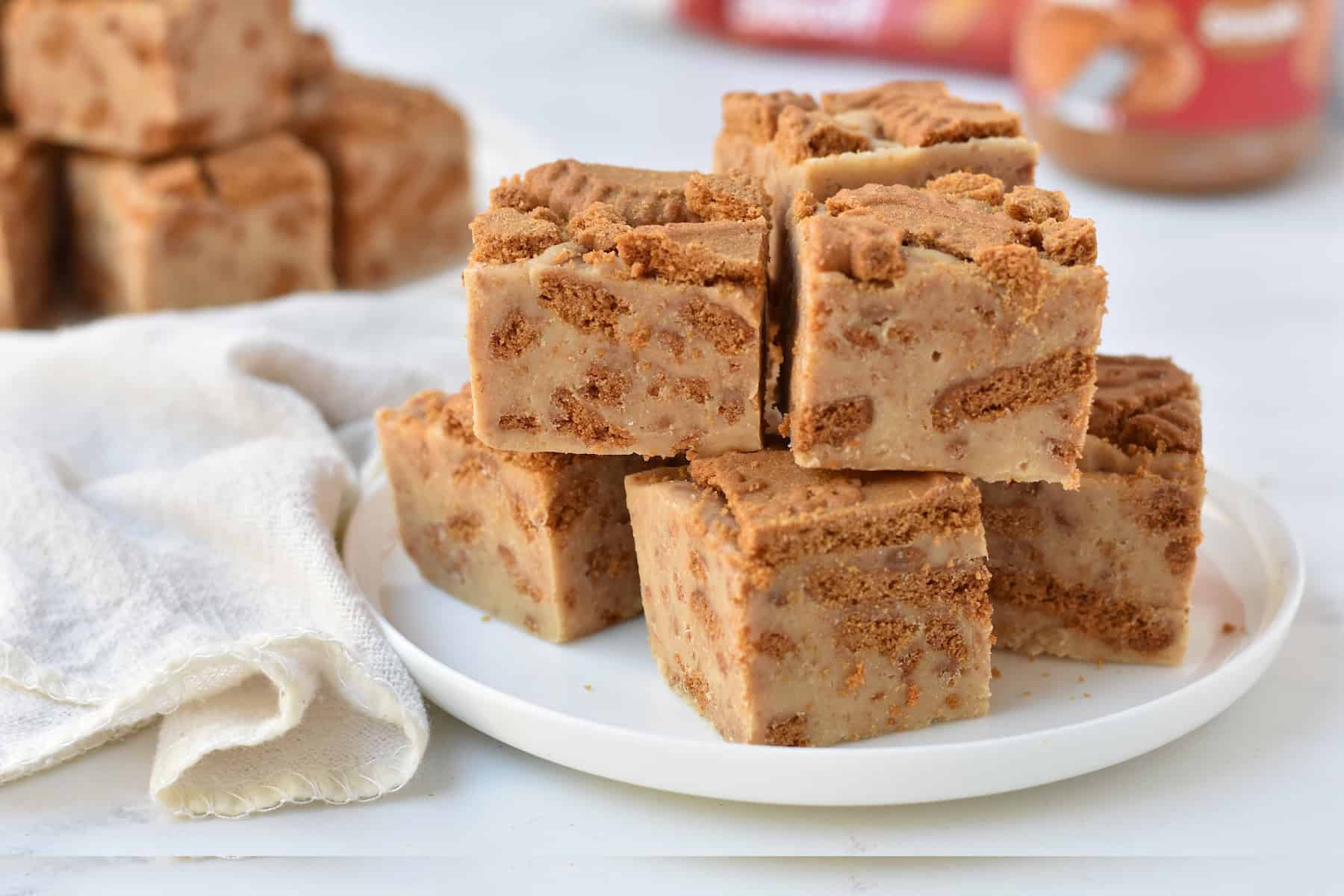 Squares of Biscoff fudge stacked on a plate.