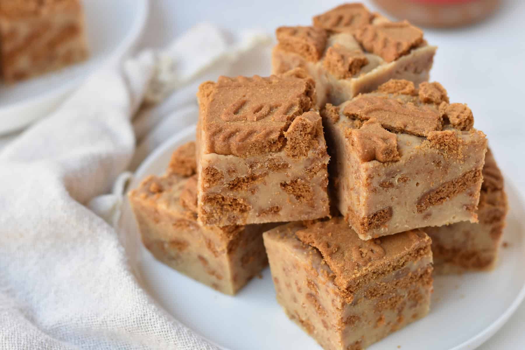 Squares of Biscoff fudge stacked on a plate.