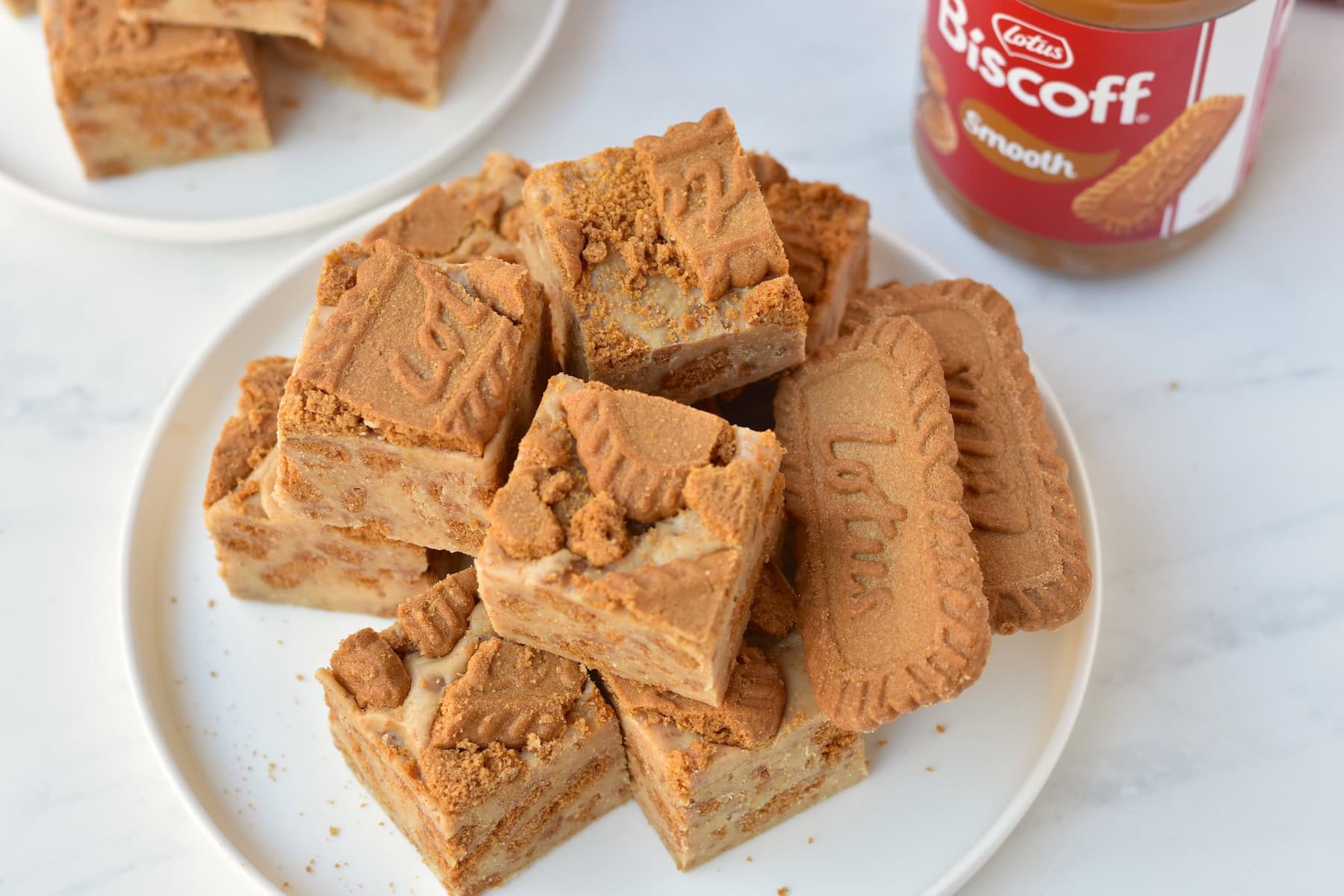 Squares of Biscoff fudge stacked on a plate.