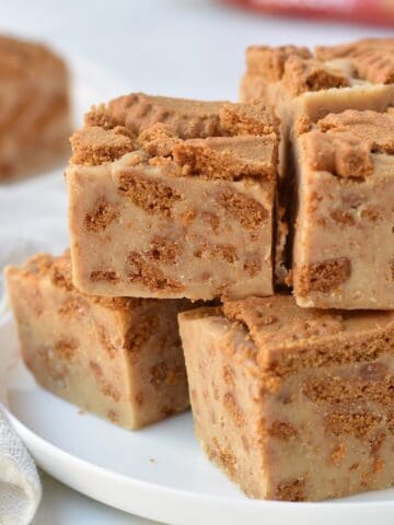 Squares of Biscoff fudge stacked on a plate.