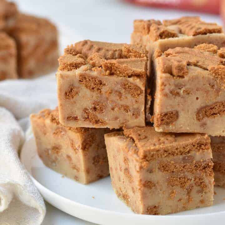 Squares of Biscoff fudge stacked on a plate.