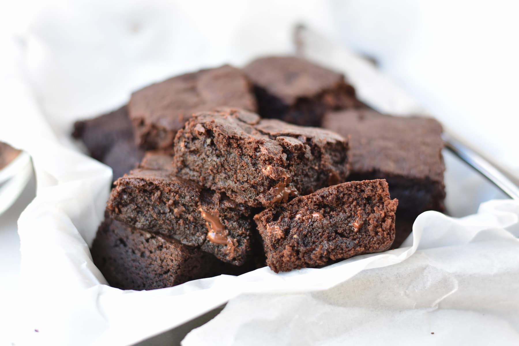 Brownies stacked in baking tray.