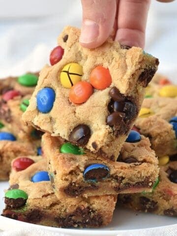 Square of cookie bar being picked up off plate.