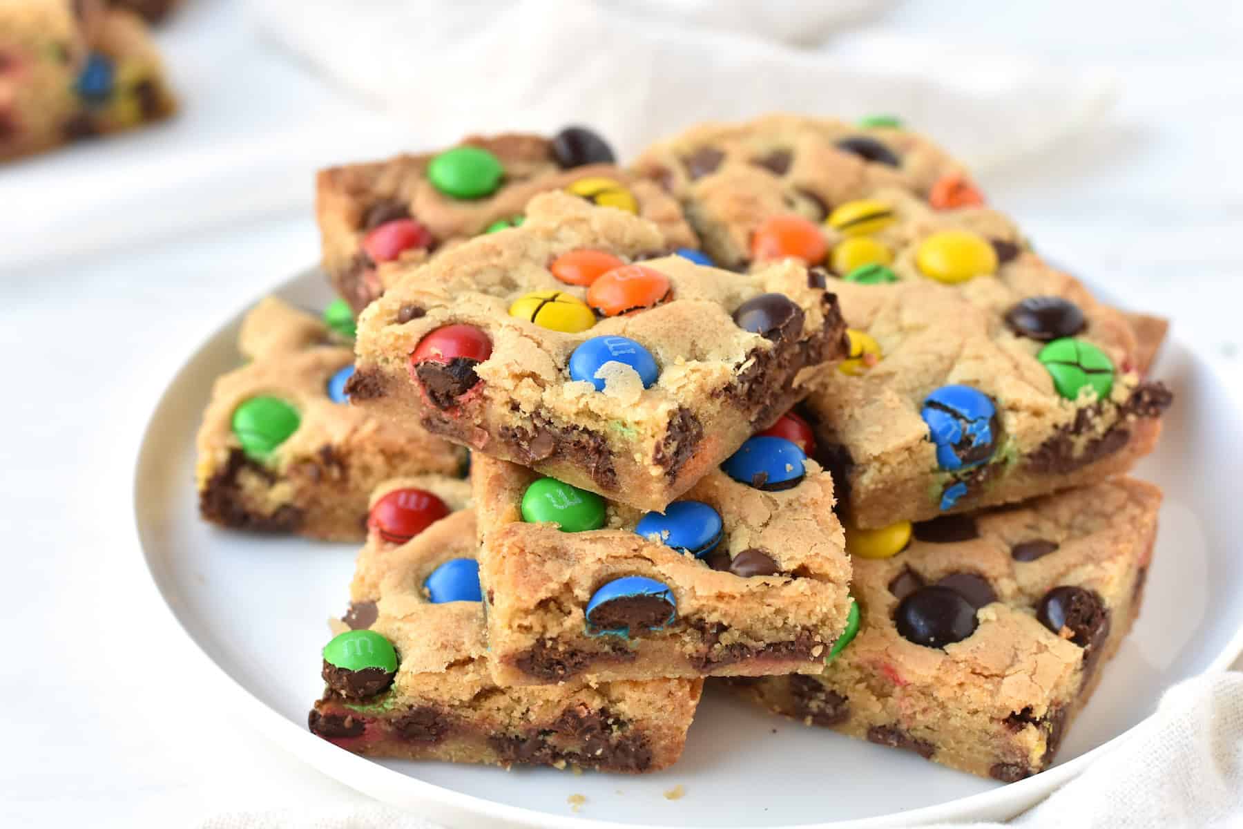 Squares of cookie bar stacked on plate.