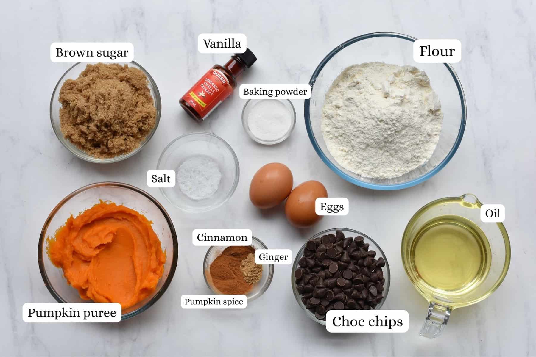 Ingredients of pumpkin muffins in bowls photographed from above.