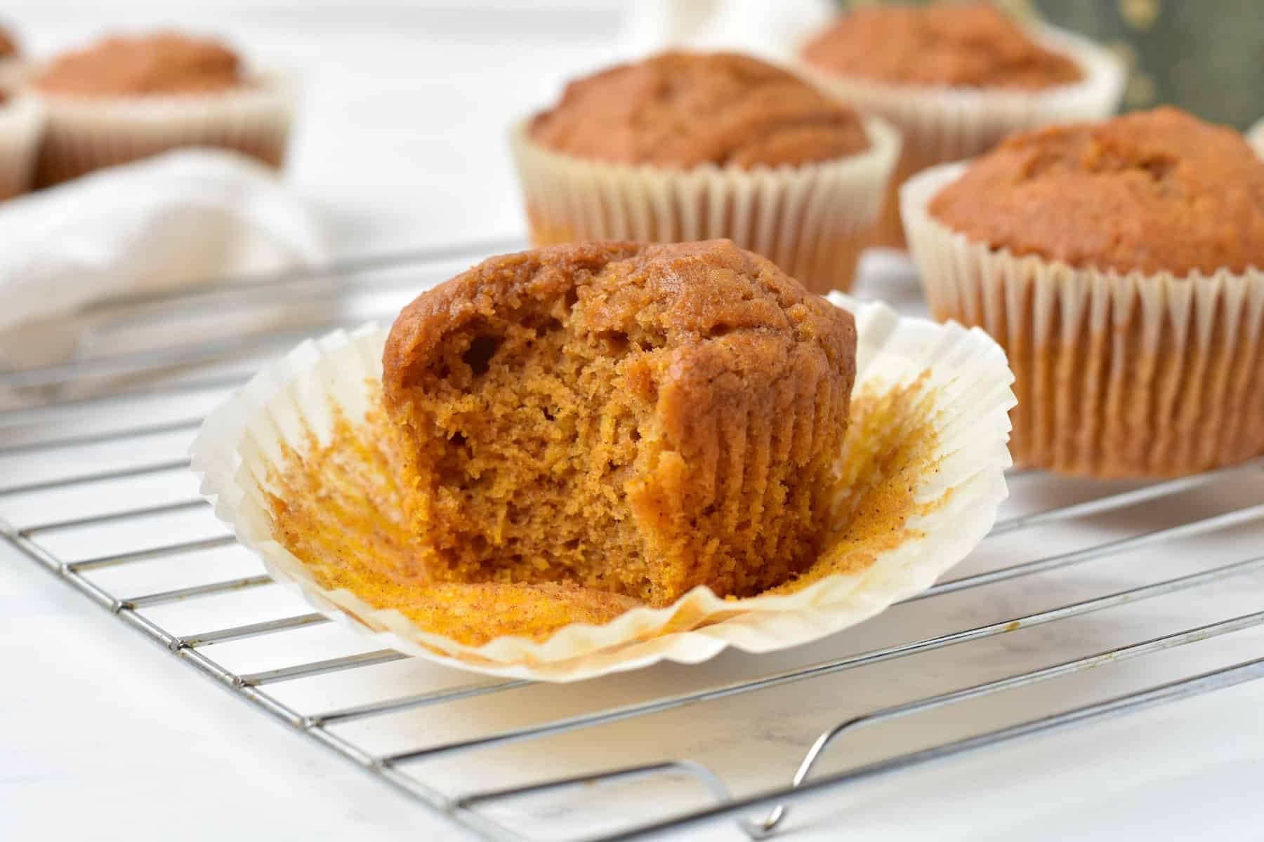 Pumpkin muffin unwrapped on a wire rack.