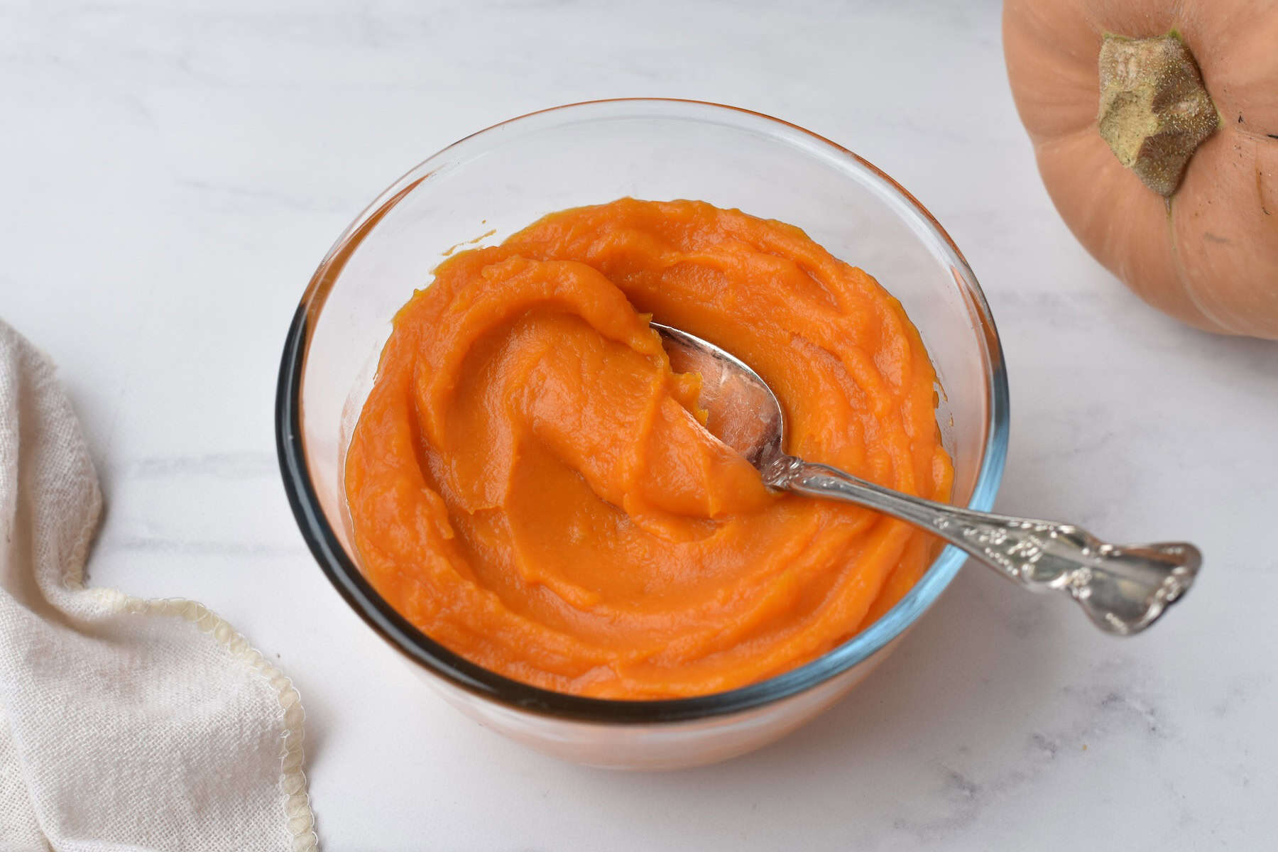 Pumpkin puree in a bowl with a spoon.