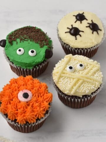 Four Halloween cupcakes with different designs.