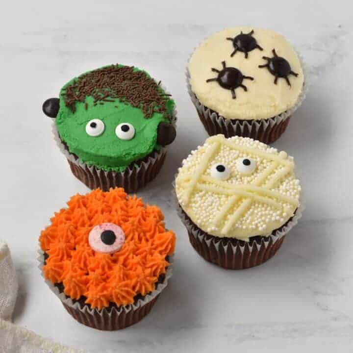 Four Halloween cupcakes with different designs.